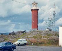 Vue panoramique de la tour Bickford démontrant la tour octogonale en brique de quatre étages, semblable à un phare, ainsi que le couronnement de brique en encorbellement placé sous le plancher en surplomb, en béton et en fer, du local de signalisation vit; Parks Canada Agency / Agence Parcs Canada, n.d.
