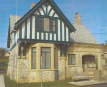 Exterior view of the Belmont Road Main Gatehouse, showing the building’s asymmetrical composition which features a square ground floor plan, surmounted by an overhanging L-shaped second floor and hipped roof, 2000.; Department of National Defence/Ministère de la Défense nationale, D. Cebula, 2000.