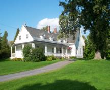 Vue générale de la Maison-de-Sir-John-Johnson, montrant l’élévation principale symétrique à cinq baies avec entrée centrale, pignon et cheminée, et les fenêtres régulièrement espacées, 2005.; Parks Canada Agency/Agence parcs Canada, 2005.