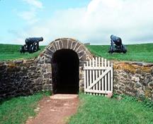 Vue de la façade générale de la poudrière du trou noir, qui montre le traitement architectural et l’emplacement sécuritaire de l’entrée, 1994.; Parks Canada Agency / Agence Parcs Canada, J.P. Jérôme, 1994.