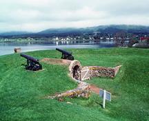 Vue générale de la Poudrière du trou noir montrant  le monticule de terre couvrant la poudrière et les murs incurvés en moellons, 1994.; Parks Canada Agency / Agence Parcs Canada, J.P. Jérôme, 1994.