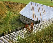Vue de la façade est de la caponnière, qui montre les murs de maçonnerie massifs en pierre à assises régulières à l’extérieur, 1980.; Parks Canada Agency / Agence Parks Canada, K. Darowski, 1980