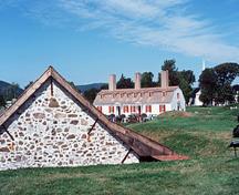General view of the Fort Anne National Historic Site of Canada showing some surviving remnants of the original fort such as the Powder Magazine (left) and the Officer's Quarters (right), 1977.; Parks Canada Agency / Agence Parcs Canada, T. Grant, 1977.