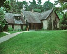 Vue de la façade de la maison, qui montre la lucarne à toit en appentis et le toit à deux versants très pentu, 2003.; Parks Canada Agency / Agence Parcs Canada, B. Morin, 2003.