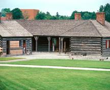 General view of the Officers' Quarters showing the hipped roof, the hand split cedar shakes used for roof cladding, and the balanced, symmetrically placed chimneys, 1985.; Parks Canada Agency / Agence Parcs Canada, B. Morin, 1985.