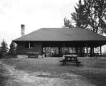 General view of the Pavilion's south elevation showing the sides of the building that are open except for the west end which is clad both on the interior and exterior with log siding, 1984.; Parks Canada Agency/Agence Parcs Canada, R. Sutart, 1984.