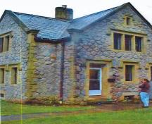 Corner view of the Gatehouse Lodge showing the tall, casement windows with stone-mullioned frames, some of which are grouped in triplets, 2000.; Department of National Defence / Ministère de la Défense nationale, 2000.