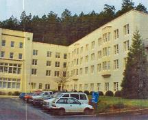 General view of the front facade of the Nixon Block RR24A showing elements influenced by the Tudor Revival Style such as the three-storey mullioned bay windows, the engaged buttresses, and the decorative shields, 2000.; Department of National Defence / Ministère de la Défense nationale, 2000.