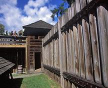 General view of the entrance to the Northeast Bastion showing its two-storey structure built of squared logs with a slightly flared, pyramidal roof, 2004; Parks Canada Agency/Agence Parcs Canada, J. Gordon, 2004