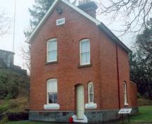 Vue générale du Quartiers des adjudants montrant le volume rectangulaire simple de ce bâtiment de deux étages à pignons en façade, 1997.; Parks Canada Agency / Agence Parcs Canada, J. Mattie, 1997.