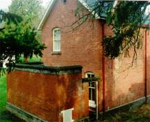 Vue en angle de l'arrière du Quartiers des adjudants montrant l’enclos de briques attenant, 1997.; Parks Canada Agency / Agence Parcs Canada, J. Mattie, 1997.