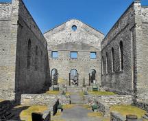 Vue de l'intérieur des Ruines de l'Église Catholique St. Raphael montrant les éléments de style palladien de la façade agrémentée d’un large fronton triangulaire, une composition à trois baies, et les fenêtres cintrées réparties avec symétrie, 2009.; Flickr, guidedbycthulhu, 2009.