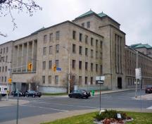 Vue en angle de l'Édifice commémoratif de l'ouest mettant de l'emphase sur l’échelle monumentale de l’édifice et sa volumétrie en gradins, les structures en acier et en béton armé revêtues de calcaire lisse avec un plinthe de granit de Stanstead, 2011.; Parks Canada Agency / Agence Parcs Canada, M. Therrien, 2011.