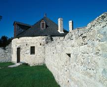 Side view of the Southwest Bastion showing the medium-pitched conical roof with two gabled dormers and three chimneys, 1989.; Parks Canada Agency / Agence Parcs Canada,  W. Lynch, 1989.
