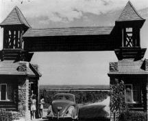 Rear view of the East Gate Entrance building, where the prominent massing of the twin kiosks and overhead gateway can be seen.; Agence Parcs Canada / Parks Canada Agency.