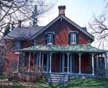 Vue générale de la Maison-Hillary qui montre la véranda richement ornée donnant sur les côtés avant, nord et sud de la maison.; Parks Canada Agency / Agence Parcs Canada.