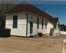 Vue générale du Bâtiment 1004, élévations de l'arrière (est) et de l'extrémité sud.; Parks Canada Agency / Agence Parcs Canada, Ian Doull, 1989.