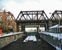 Vue générale du Canal-de-Sainte-Anne-de-Bellevue, qui montre les murs d’entrée amont et aval de l’écluse, ainsi que le couronnement en maçonnerie de pierre, 2003.; Parks Canada Agency / Agence Parcs Canada, 2003.