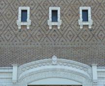 Detail view of Royal Theatre, showing ground floor terra cotta facing laid to resemble stone, the polychrome and banded, diamon-patterned brickwork, 2011.; Parks Canada Agency / Agence Parcs Canada, Andrew Waldron, 2011.