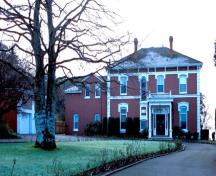 Vue générale de la résidence de l’amiral et ancienne maison du magasinier, qui montre l’entrée principale avec son portique à colonnes.; Parks Canada Agency / Agence Parcs Canada, Ian Doull.
