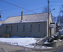 Vue de côté de l'ancien hangar d'exercices d'Elora, qui montre ses fenêtres à guillotine à vitres multiples réparties régulièrement  et sa construction en pierre, 1995.; Parks Canada Agency / Agence Parcs Canada, J. Butterill, 1995.