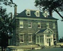 Vue générale de l'Édifice-de-l'Amirauté qui montre sa masse rectangulaire à deux étages, son toit en croupe avec lucarnes et ses cheminées d'extrémité.; Parks Canada Agency / Agence Parcs Canada.
