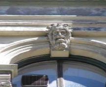 Détail d'un bâtiment de l’îlot Granville, qui montre une des clés de voûte sculptées dans les fenêtres cintrées et les ouvertures, 2005.; Parks Canada Agency / Agence Parcs Canada, 2005.