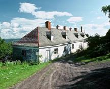 Vue générale du bâtiment 16 montrant le toit en croupe à ossature en bois percé de lucarnes et de cheminées de maçonnerie, vers 2004.; Parks Canada Agency | Agence Parcs Canada, circa | vers 2004