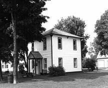 Vue générale de la résidence fortifiée du maître-éclusier, qui montre la symétrie et les matériaux des façades principales, 1989.; Parks Canada Agency / Agence Parcs Canada, Couture, 1989.