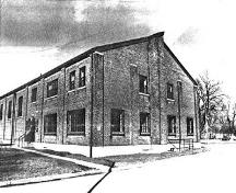 Corner view of 'O' Block, showing the rectangular massing, symmetry, and proportions of the gable-roofed structure with narrow eaves.; Parks Canada Agency / Agence Parcs Canada.