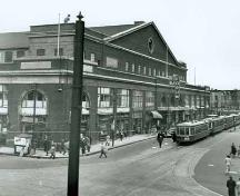 The south (Sainte-Catherine Street) façade of the Montréal Forum showing the original appearance of the structure with its commercial premises along the south and west (left side of the photograph) elevations, April 1947.; Library and Archives Canada, National Film Board, Phototèque Collection | Bibliothèque et Archives Canada, Office national du film, Collection Phototèque, PA129603.