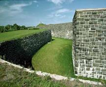 Vue générale du fossé, principale obstacle défensif qui ceinture le fort, 1984.; P. St. Jacques, Parks Canada Agency / Agence Parcs Canada, 1984.