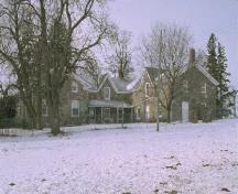 General view of the stone house on Thistle Ha' Farm, showing its one-and-a-half-storey tripartite massing under gable roofs, 1991.; Parcs Canada | Parks Canada