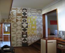 Vue de l'intérieur de la Maison Binning, qui montre la murale au fond de la longue galerie-entrée; Parks Canada | Parcs Canada