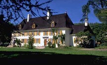 Vue générale du manoir Mauvide-Genest, qui montre la façade à neuf baies avec ses fenêtres à battants en bois régulièrement espacées et ses deux portes.; Parks Canada Agency / Agence Parcs Canada.