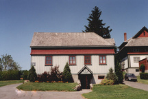 Vue de l'extérieur de l'atelier de rempotage, qui montre le tablier évasé en bardeaux de l’étage, 1995.; Parks Canada Agency / Agence Parcs Canada, 1995.