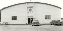 General view of Hangar 3, showing the central entrance and low, bowed roof, 1987.; Department of National Defence / ministère de la Défense nationale, 1987.
