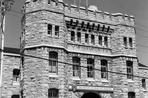 Façade du manège militaire, qui montre un avant-corps de trois étages terminé par un fronton, muni d’une porte d’entrée pour les troupes flanquée de deux tourelles dans lesquelles se trouvent les escaliers, 1989.; Parks Canada | Parcs Canada, J. Adell, 1989.
