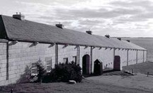 Vue générale du magasin de l'intendance et de la chambre de tir à revers ouest , montrant le groupement géométrique simple qu’évoque ce bâtiment rectangulaire en pierre calcaire taillée, 1996.; Parks Canada | Parcs Canada, Graham, 1996.