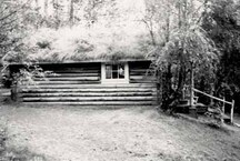 Side view of the Robert Service Cabin, showing the rustic, low-lying form, 1987.; Parks Canada | Parcs Canada, 1987.